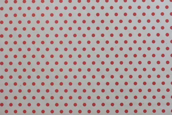 Red dots on cream paper